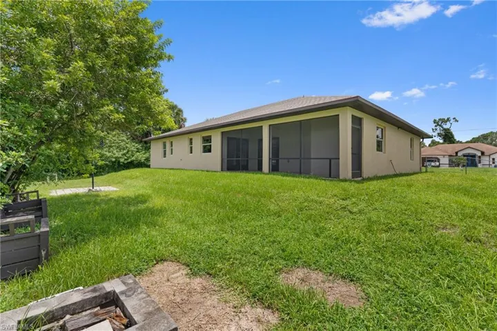 Back of property featuring stucco siding and a yard
