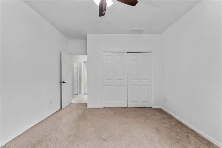 Unfurnished bedroom featuring carpet floors, a closet, and ceiling fan