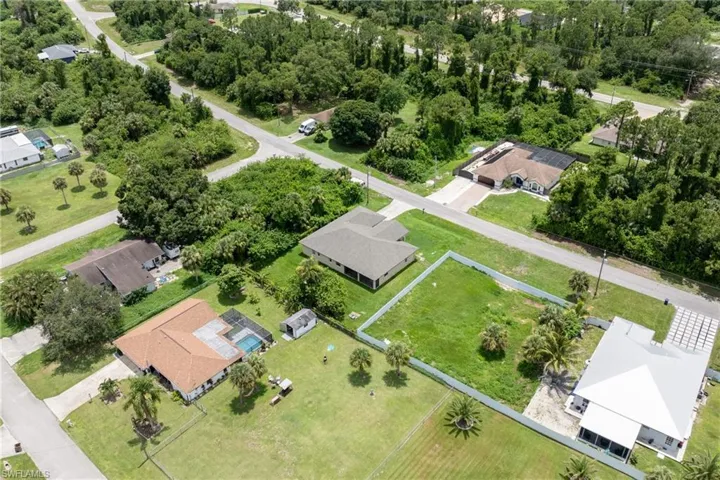 Aerial view of property and surrounding area featuring nearby suburban area