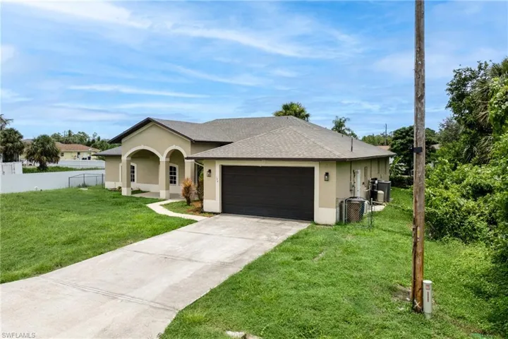 Ranch-style home featuring stucco siding, an attached garage, concrete driveway, and roof with shingles