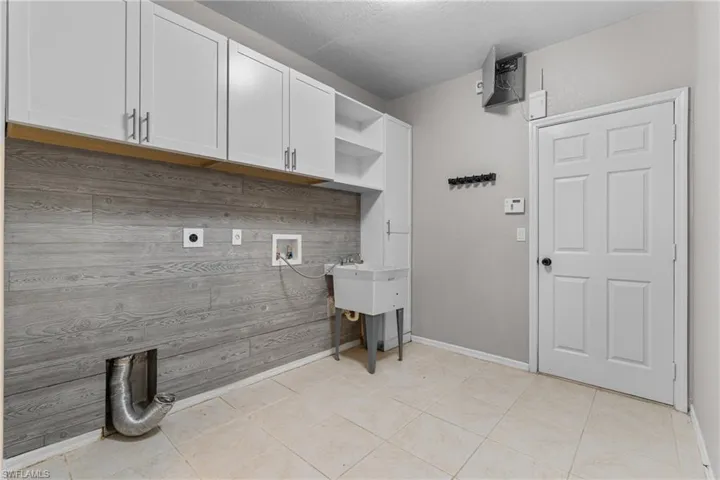 Laundry area with cabinet space, electric dryer hookup, and hookup for a washing machine