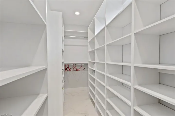 Spacious closet with light marble finish floors