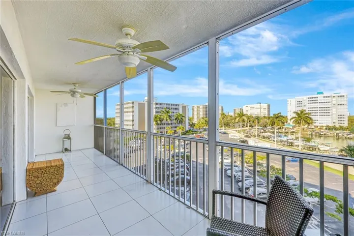 Unfurnished sunroom with expansive windows, a city view, a water view, a textured ceiling, and tile patterned floors