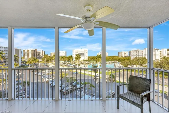Sunroom / solarium with floor to ceiling windows, a water view, plenty of natural light, a view of city, and a textured ceiling