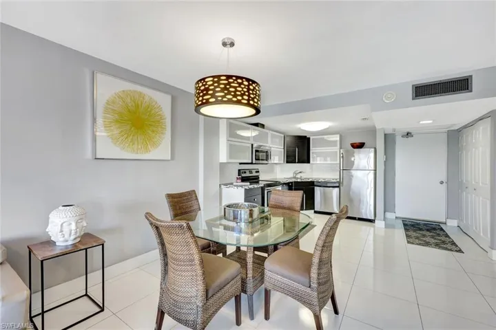 Dining space with light tile patterned flooring and baseboards