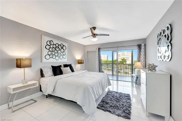 Bedroom with access to exterior, a ceiling fan, and light tile patterned floors