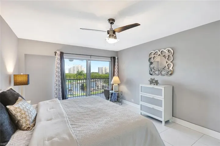 Bedroom featuring light tile patterned flooring, access to outside, and a ceiling fan