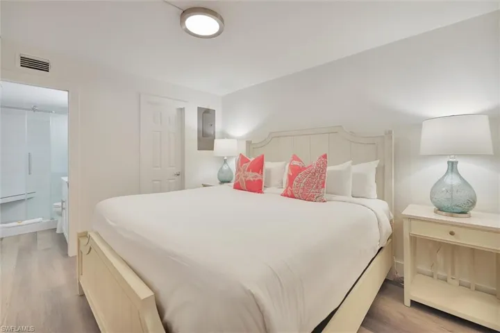 Bedroom with light wood finished floors and electric panel
