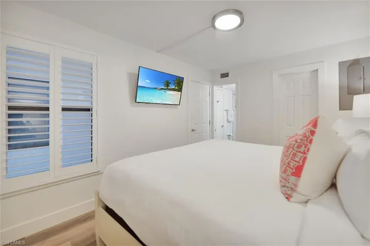 Bedroom with light wood-style floors and electric panel