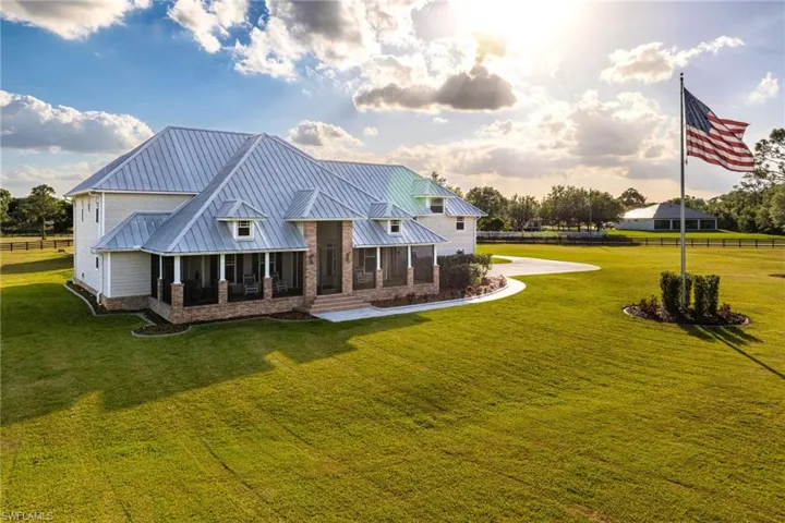 front of house featuring a yard, covered porch, metal roof, and a standing seam roof