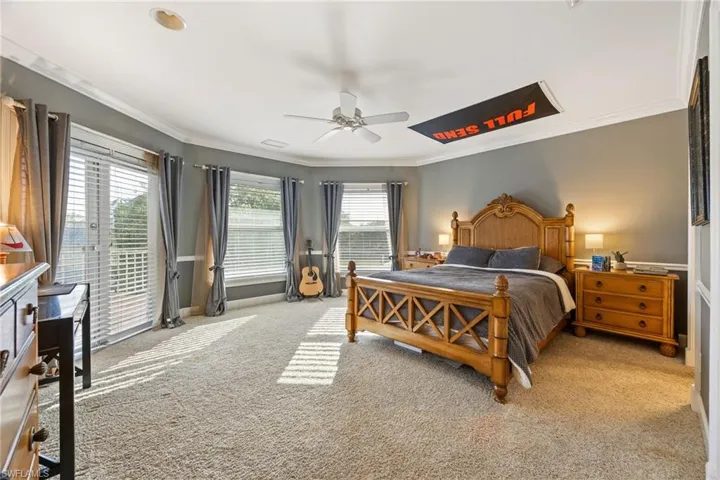 Bedroom with visible vents, ceiling fan, crown molding, access to exterior, and light carpet