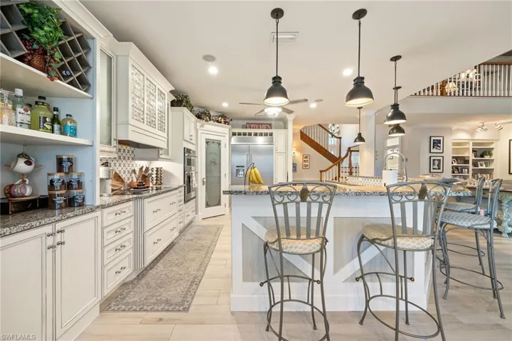 Kitchen featuring tasteful backsplash, visible vents, ceiling fan, light stone countertops, and stainless steel appliances