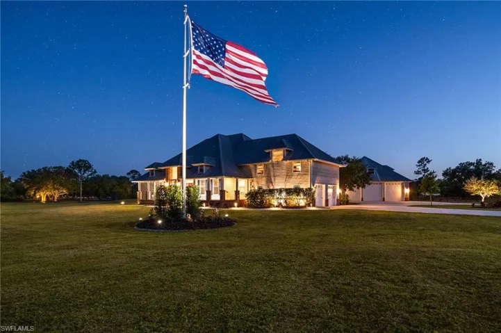 View of front of home featuring driveway, a garage, a front lawn, and metal roof