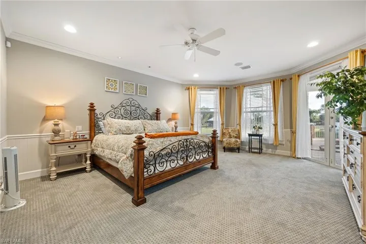 Bedroom featuring crown molding, visible vents, access to outside, and wainscoting
