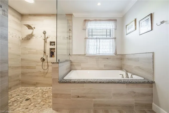 Full bathroom with crown molding, walk in shower, and a garden tub