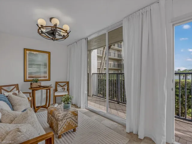 Bonus Sitting Room with stone tile floor and a full wall of new impact glass sliders, perfect for enjoying the sunrise and morning coffee. Owner moved entrance door to allow this space to be enjoyed year round.