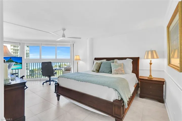 Bedroom with multiple windows, access to exterior, a wall of windows, and ceiling fan