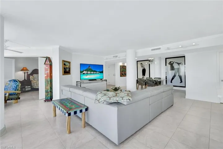 Living room with crown molding and light tile patterned flooring