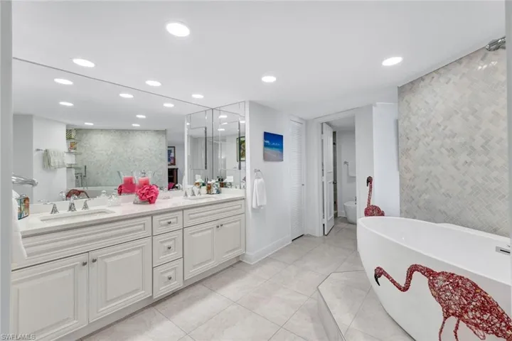Full bathroom featuring independent shower and bath, vanity, tile patterned flooring, and toilet