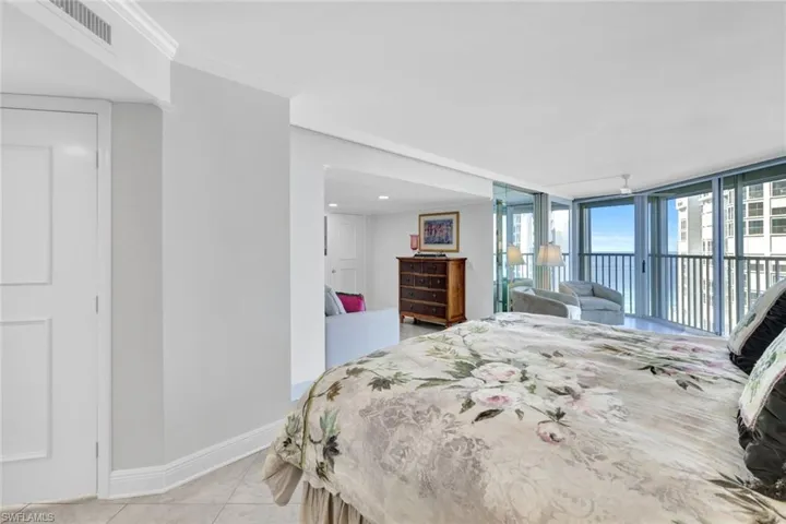 Tiled bedroom with crown molding and access to outside