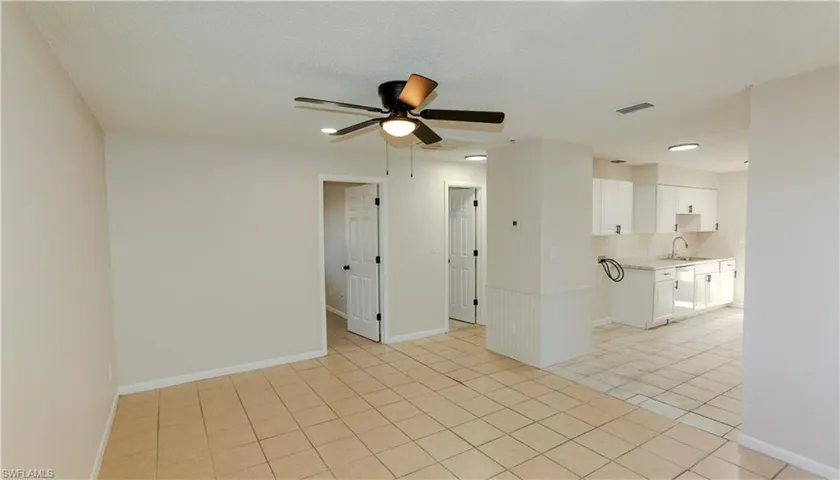 Open-concept living area featuring neutral wall tones and light-colored tile flooring