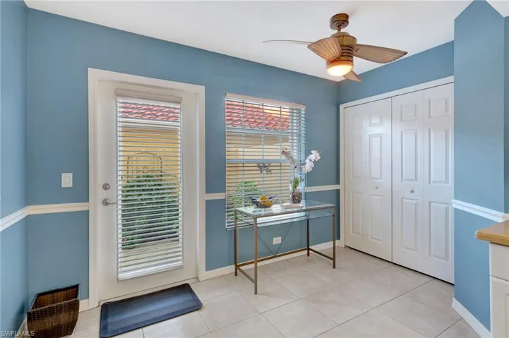Doorway to outside with baseboards, a ceiling fan, and light tile patterned flooring