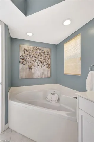 Bathroom with a wealth of natural light, vanity, a bath, and tile patterned floors