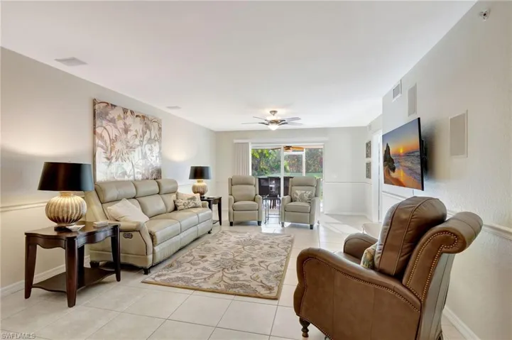 Living area featuring a ceiling fan, visible vents, baseboards, and light tile patterned floors
