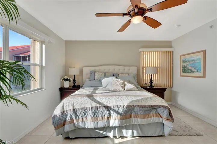 Bedroom with light tile patterned floors, a ceiling fan, and baseboards