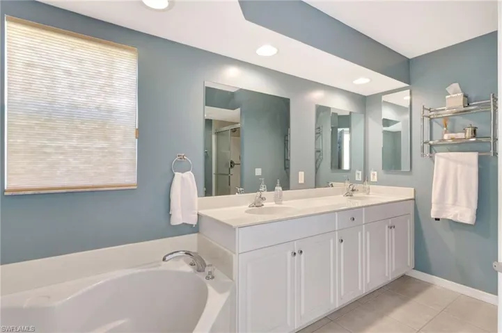 Full bathroom with a stall shower, a sink, a bath, and tile patterned floors