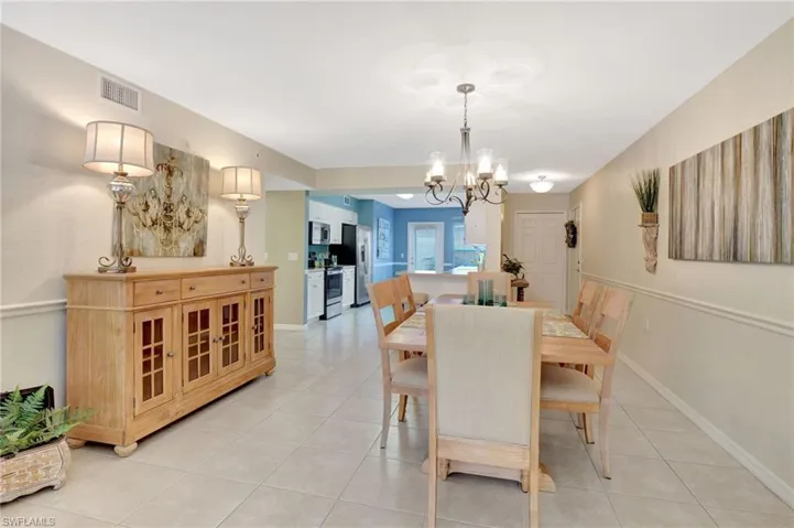 Dining space with light tile patterned floors, baseboards, visible vents, and a chandelier