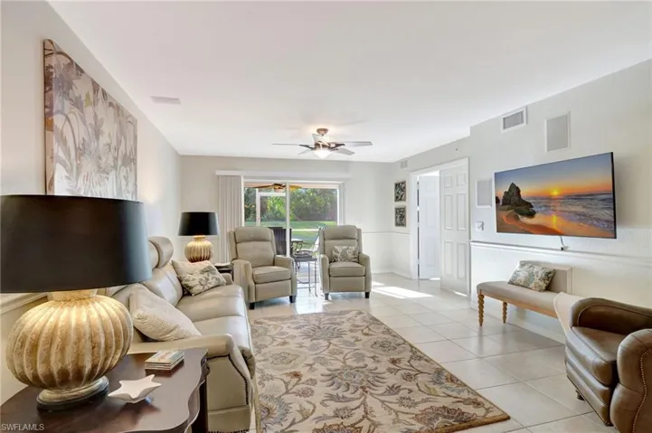 Living room featuring a ceiling fan, visible vents, and light tile patterned floors