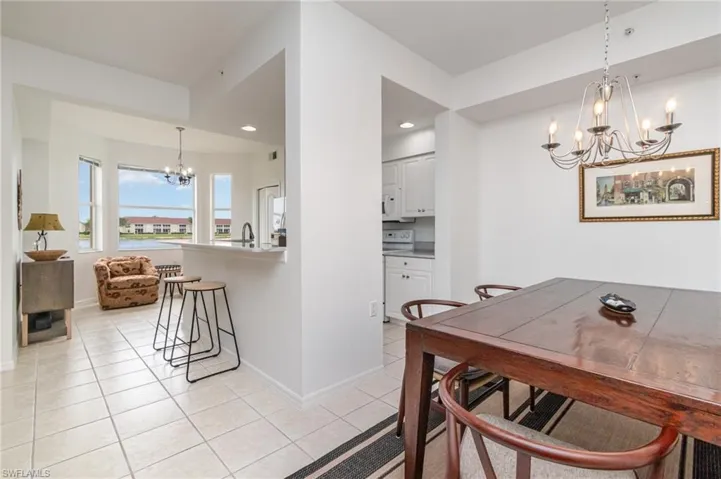Dining space with a chandelier, light tile patterned floors, baseboards, and recessed lighting
