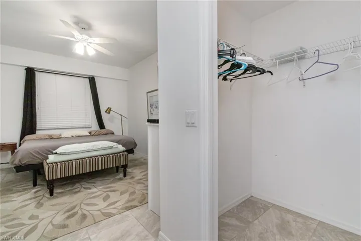 Walk in closet featuring ceiling fan and light marble finish flooring