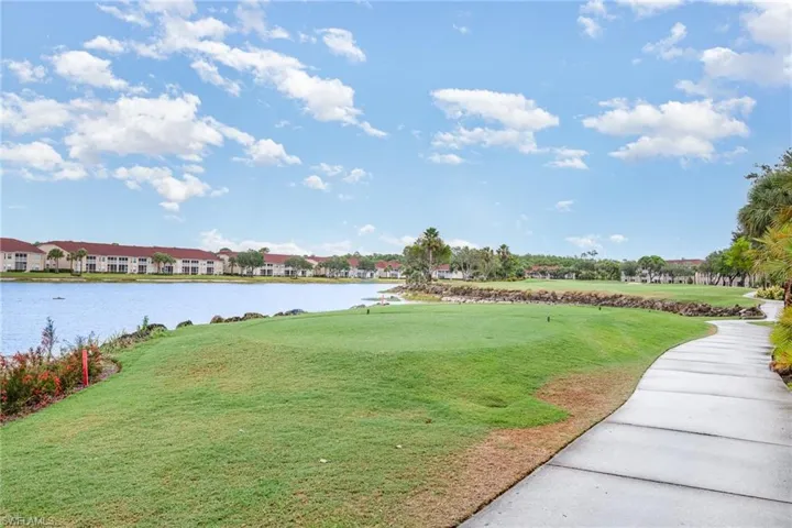View of home's community with a water view and a lawn