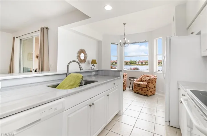 Kitchen featuring white appliances, a sink, light tile patterned flooring, light countertops, and recessed lighting