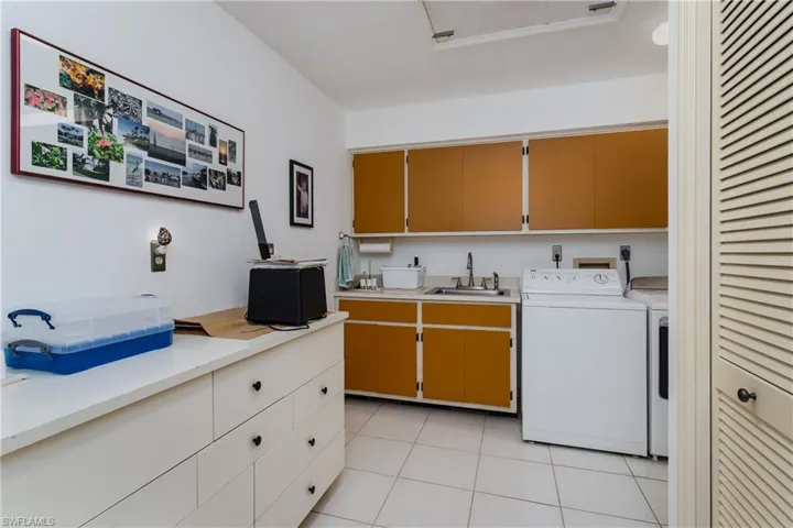 Laundry room featuring cabinet space, washer and dryer, and light tile patterned flooring