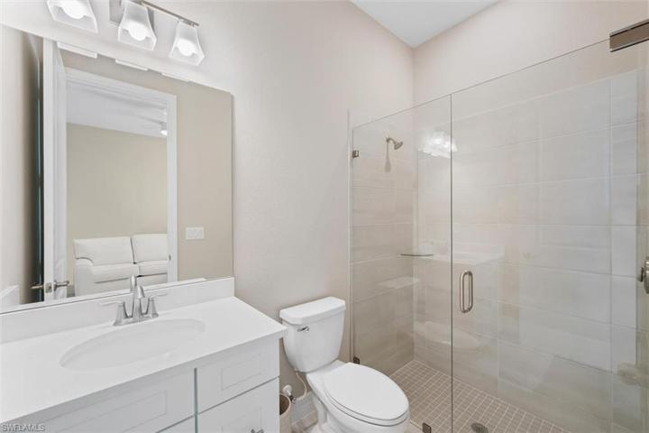 En-suite guest bathroom with custom, frameless shower door.