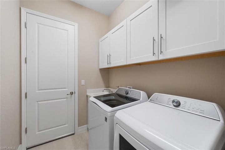 Laundry room with utility sink and cabinets.