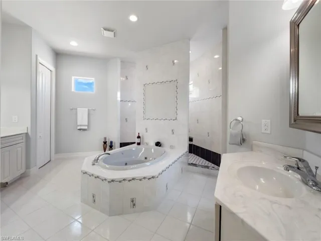 Bathroom featuring vanity, a whirlpool tub, tile patterned flooring, recessed lighting, and a tile shower