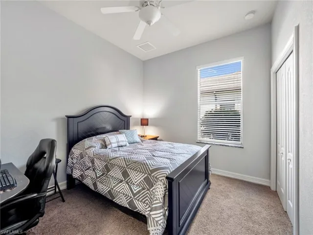 Carpeted bedroom with baseboards and ceiling fan