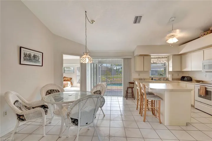 Dining area featuring vaulted ceiling and light tile patterned flooring