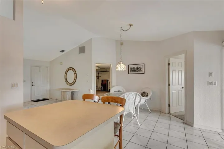 Dining room with light tile patterned flooring and lofted ceiling