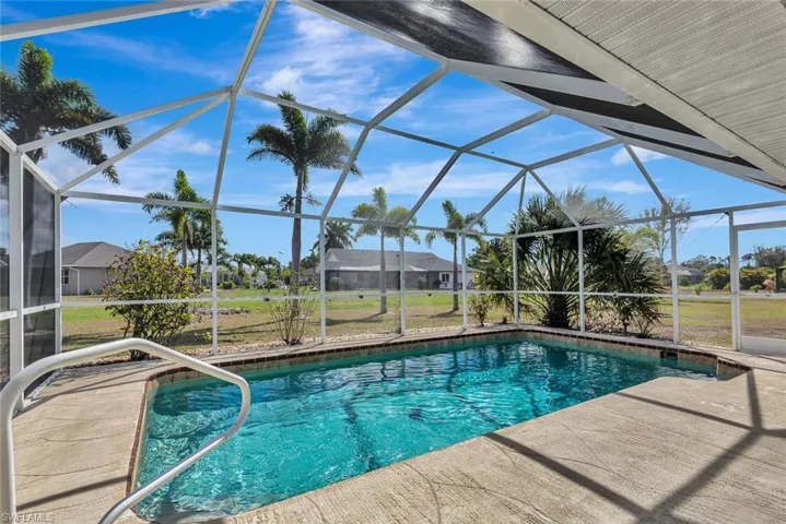 Swimming pool featuring a sunroom, a lanai, a patio, and a lawn