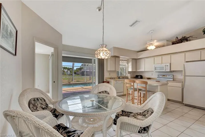 Dining space featuring vaulted ceiling, plenty of natural light, and light tile patterned floors