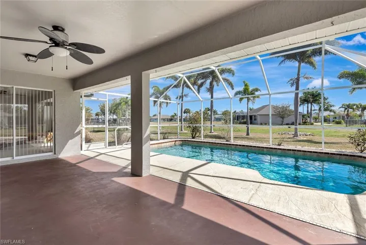 Swimming pool featuring a sunroom, a patio area, and glass enclosure
