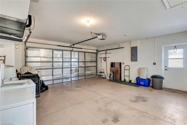 Garage featuring electric panel and electric water heater