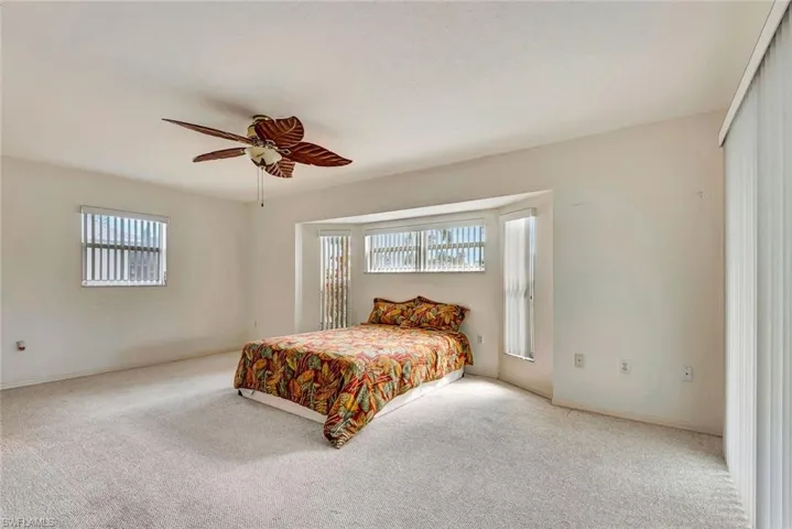 Carpeted bedroom featuring baseboards and ceiling fan