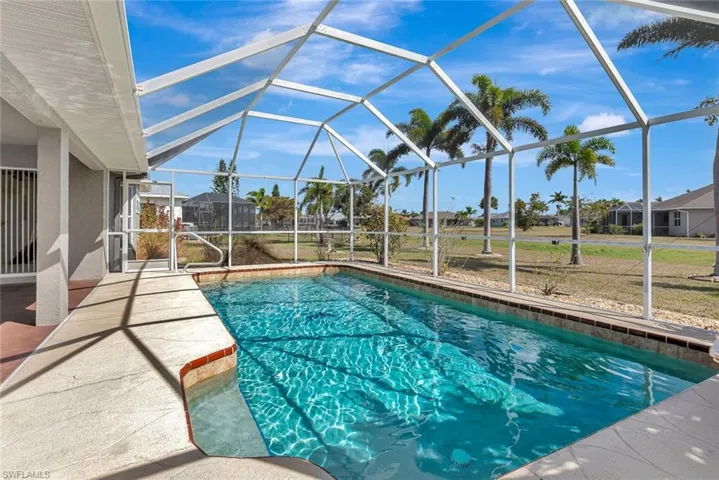 Swimming pool featuring a sunroom, a lanai, a patio, and a lawn