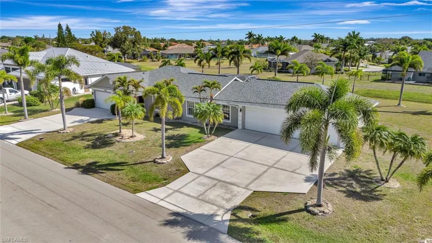 View of front of home featuring a garage, driveway, a residential view, and a front yard
